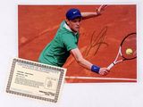 a signed photo of a tennis player about to hit the ball
