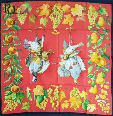 deux oiseaux suspendus à un foulard rouge