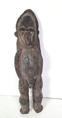 une vieille statue en bois représentant un gorille tenant un morceau de bois