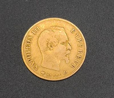 a close up of a gold coin on a black surface