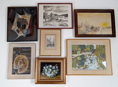 de nombreux tableaux encadrés accrochés au mur au-dessus d'un lit