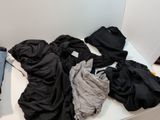 a pile of clothes sitting on a table next to a laptop