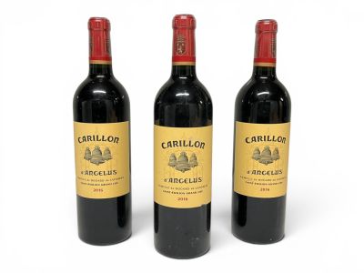three bottles of red wine sitting next to each other on a white surface