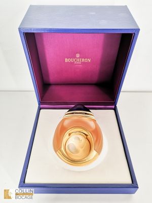 une image représentant un flacon de parfum dans un coffret violet