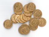 a pile of gold coins sitting on a white surface