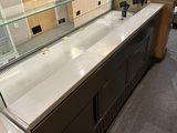 a counter with a glass display case in the middle of the room