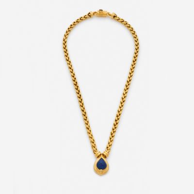 a gold necklace with a blue stone pendant on a chain