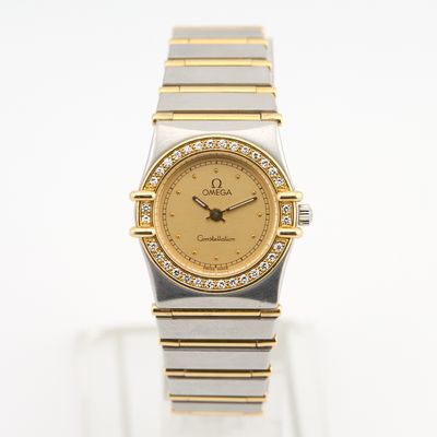 une photo d'une montre en or et en argent, avec des diamants sur le cadran