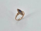 a close up of a gold ring with a blue stone