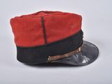 a red and black hat on a white surface