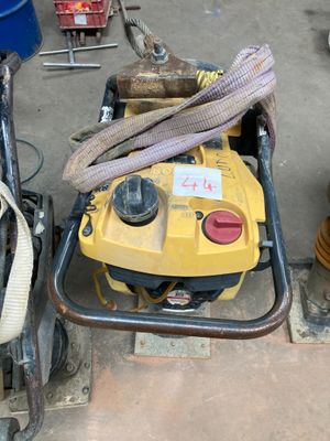une machine jaune posée par terre à côté d'un seau bleu
