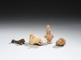 trois petites figurines représentant des animaux et un oiseau, posées sur une surface blanche