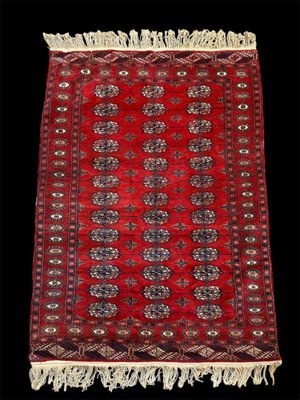 un tapis rouge et noir à franges sur fond noir