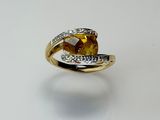 an image of a yellow sapphire and diamond ring on a white surface