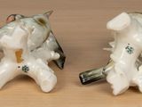 two figurines of birds sitting on a table