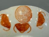 a white bowl with a red design on it