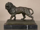 bronze statue of a lion on a marble base on a table