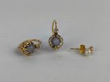 une paire de boucles d'oreilles et une boucle d'oreille en perle posées sur une surface blanche