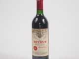 une vieille bouteille de vin rouge posée sur une table blanche
