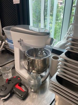 un mixeur posé sur un plan de travail, à côté d'un tas de casseroles