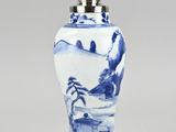 a blue and white vase with a bird on the top of it