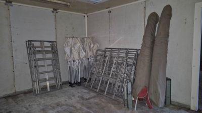 une pièce dans laquelle se trouvent plusieurs chaises et un porte-vêtements