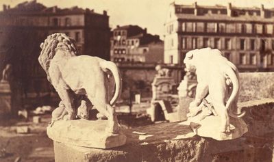 deux statues de lions au sommet d'un immeuble