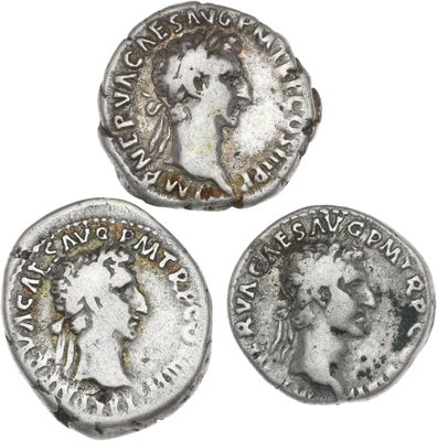 trois pièces de monnaie romaines antiques, dont l'une représente la tête d'une femme et une autre une tête