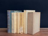three books are stacked on top of each other on a wooden table