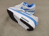 a pair of white and blue sneakers on the floor