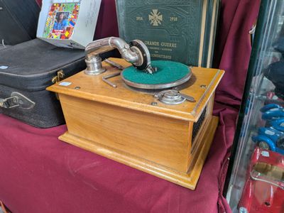 an old record player sitting on a table next to a suitcase