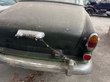 an old car that is parked on the side of the street