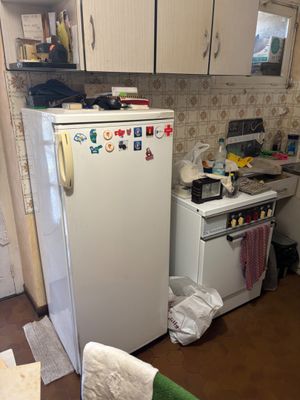 a refrigerator in the kitchen with many magnets on it