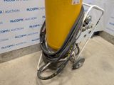 a yellow cylinder on a cart with a hose attached to it