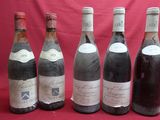 six bottles of wine are lined up on a red background