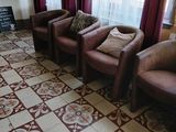 trois chaises et un canapé dans une pièce aux rideaux rouges
