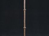 an old iron candle holder with a candle on it on a black background