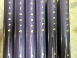 six purple books are lined up on a marble counter top