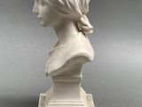 a white marble bust of a woman wearing a headscarf