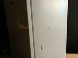 a white refrigerator sitting on a wooden table in a dark room