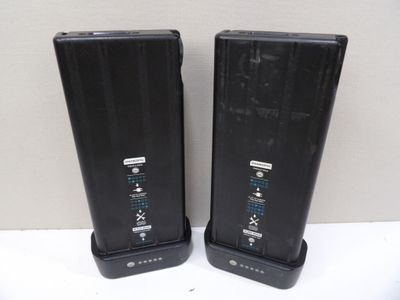two black speakers sitting on top of a white table