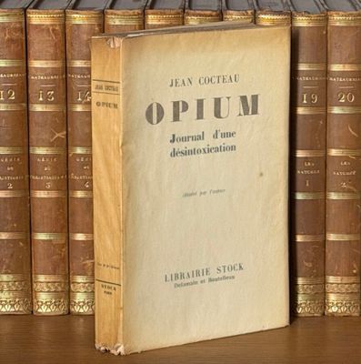 un livre posé sur une table, à côté d'une pile de livres