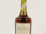 une vieille bouteille de bourbon posée sur une surface blanche