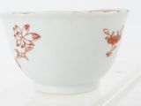 a white bowl with red flowers on it and chopsticks in the bowl