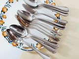 five spoons and two spoons on a plate on a table