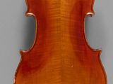 an old violin with a wooden back and bow on a gray background