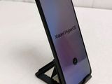 a close up of a phone on a stand on a white surface