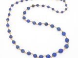 un gros plan d'un collier de perles bleues sur fond blanc