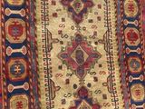an old rug hanging on a wall in a room