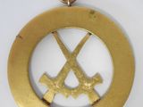 a gold medal with two crossed swords on it